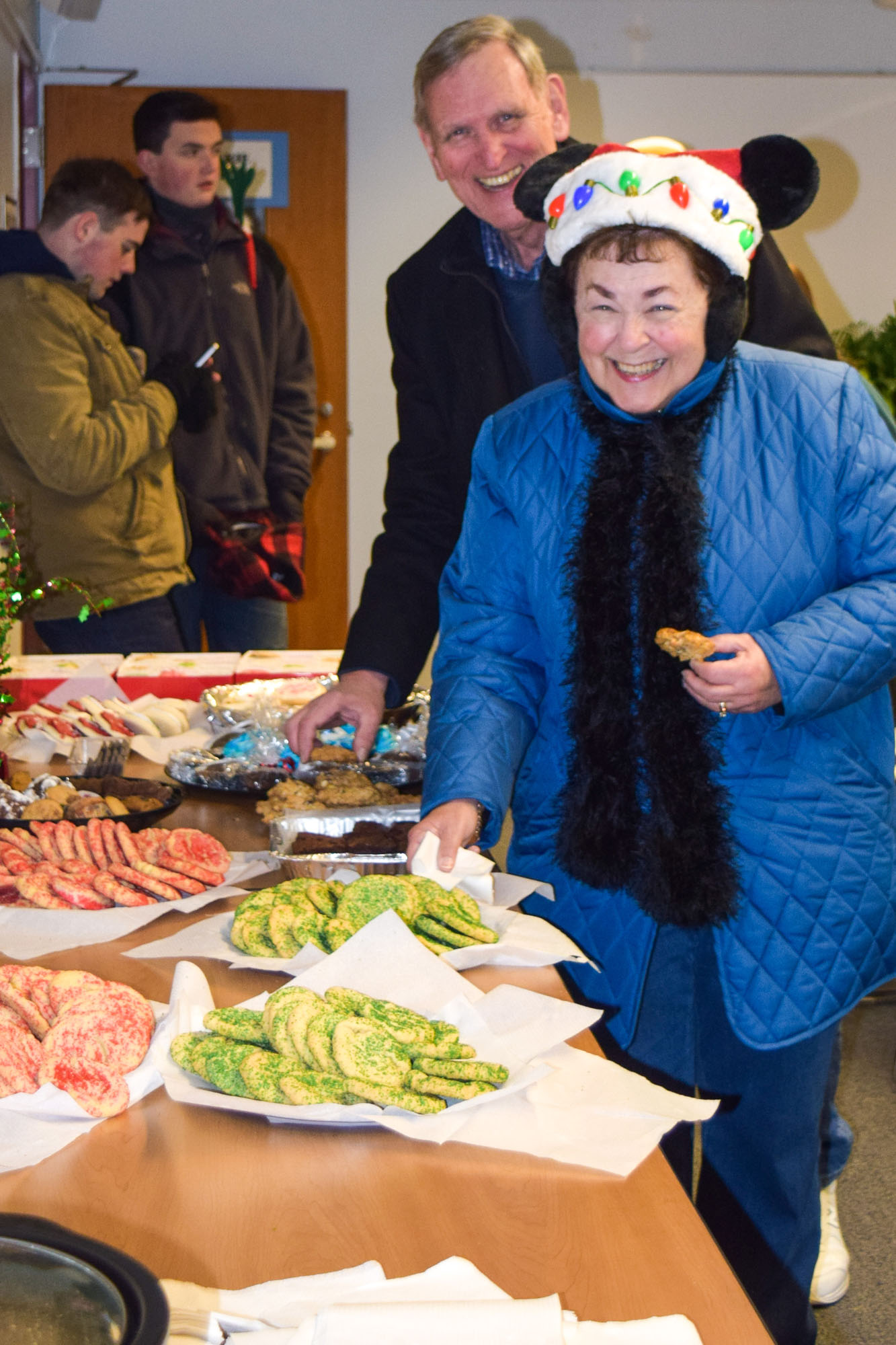 Elaine and Jerry Joy of Christmas Tree Lane Halifax share a cookie and laughter at the Holmes Public Library during Halifax holiday celebration.